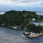 Skärgårdsö med fyr och passagerarfärjor på vattnet