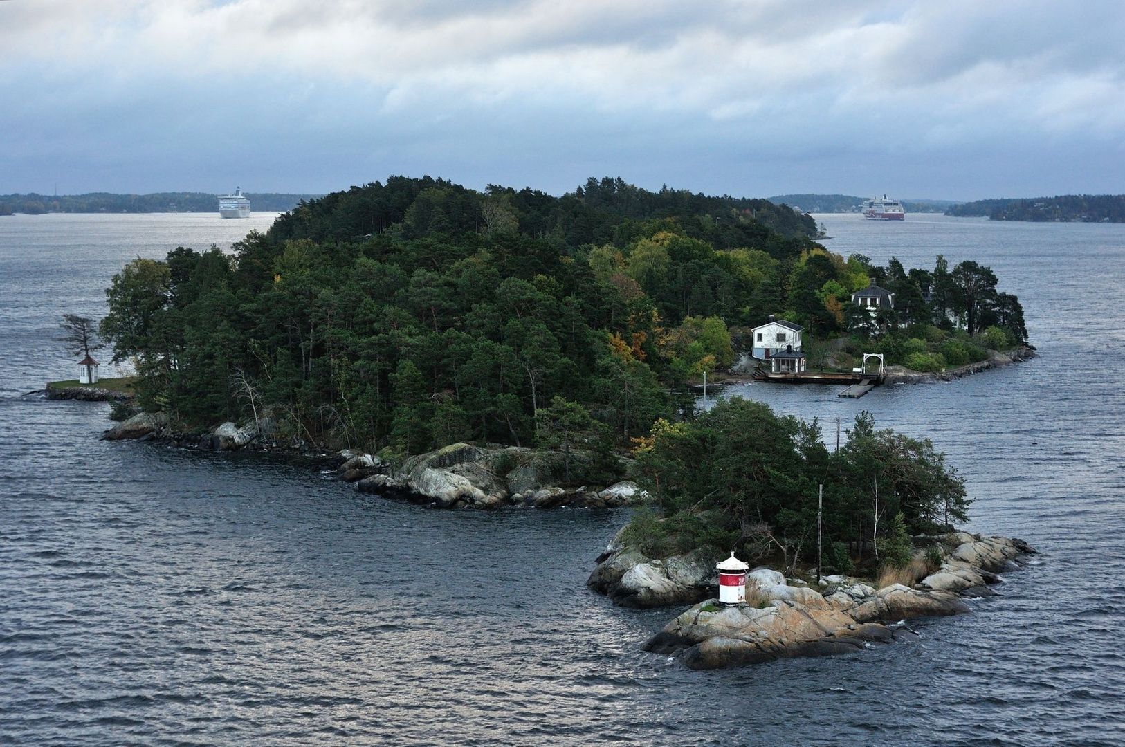 Skärgårdsö med fyr och passagerarfärjor på vattnet
